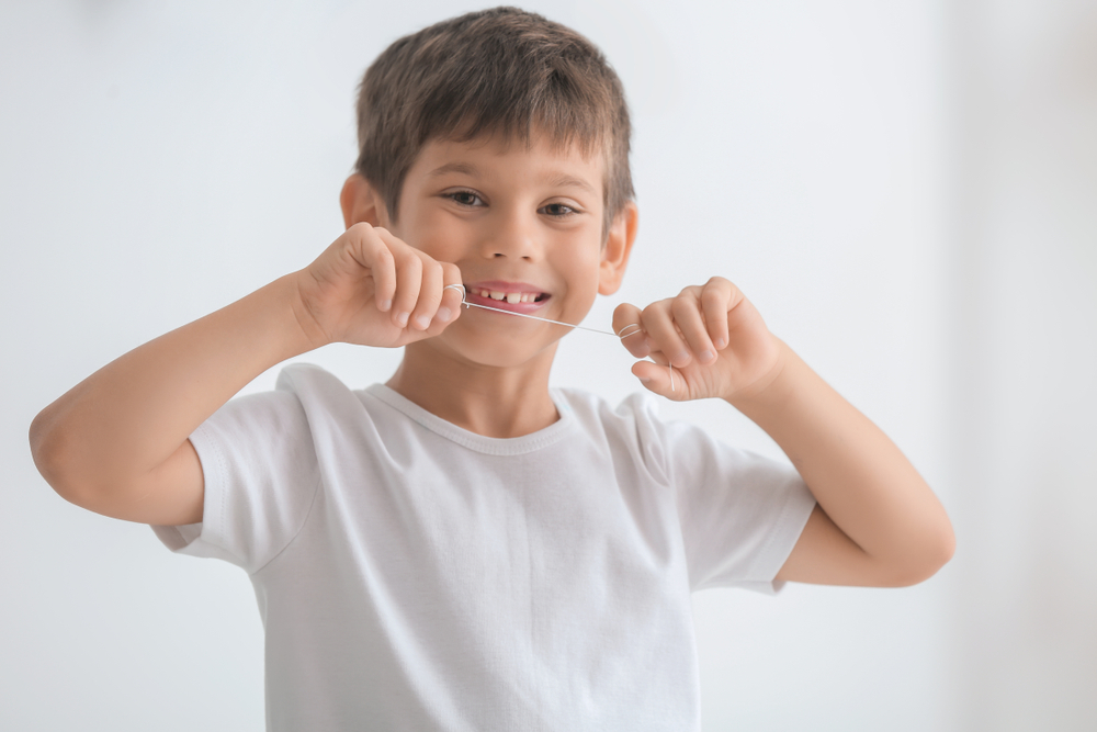 Young boy holding dental floss