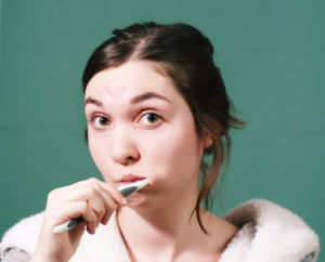 Young woman brushing teeth