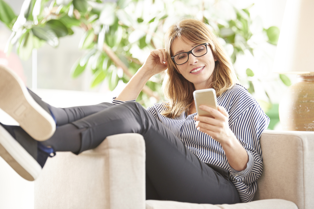 Middle-aged woman relaxing while looking at phone