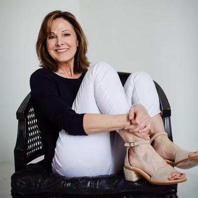 Woman sitting with arms folded across her legs